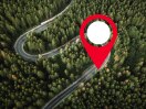 A pin icon marks the spot of a Honda on a wilderness road, tracked by Honda Plus Locate.