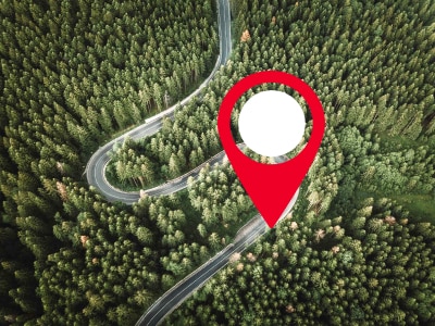 A pin icon marks the spot of a Honda on a wilderness road, tracked by Honda Plus Locate.