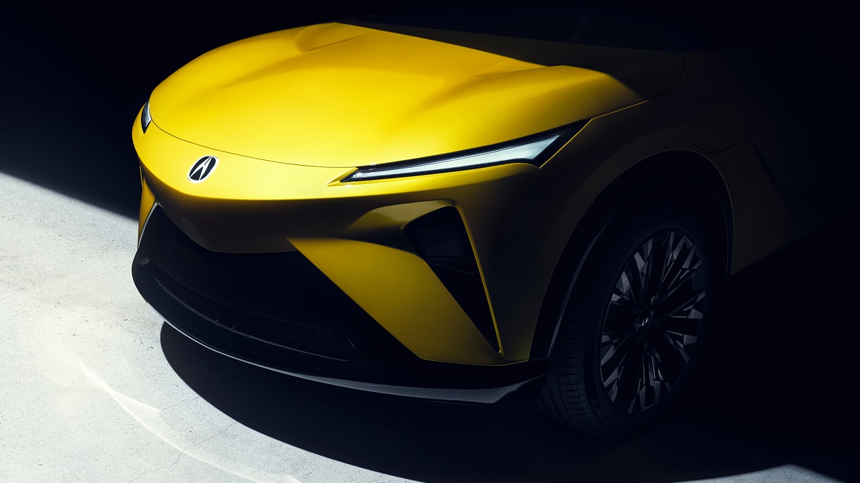 Gros plan sur l’avant d’un prototype RSX doré sur fond noir ombragé.  