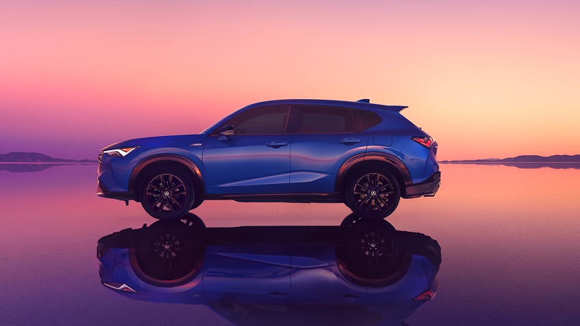 Side-view of an Acura ADX with pink sunset in the background.