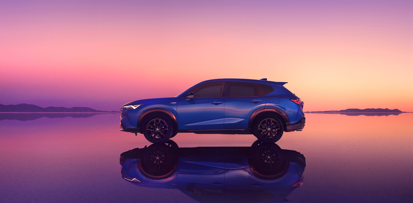 Acura ADX vu de côté devant un coucher de soleil rose.