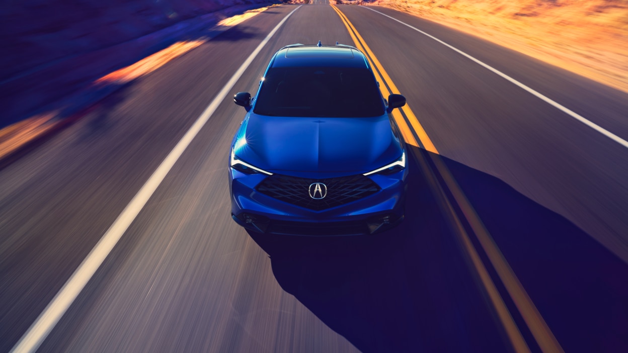 Acura ADX vu de l’avant sur une autoroute avec des lignes bleues sortant de la calandre.