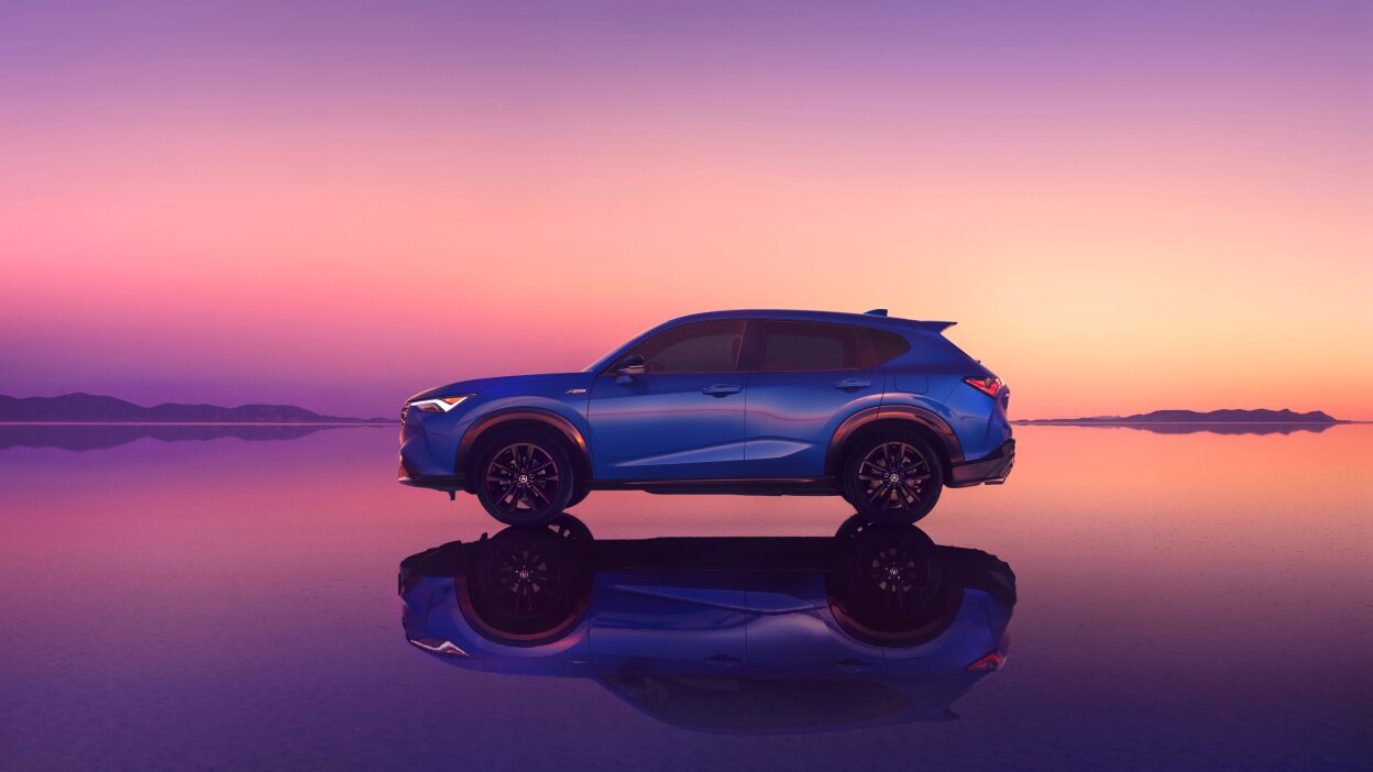 Acura ADX vu de côté devant un coucher de soleil rose. 