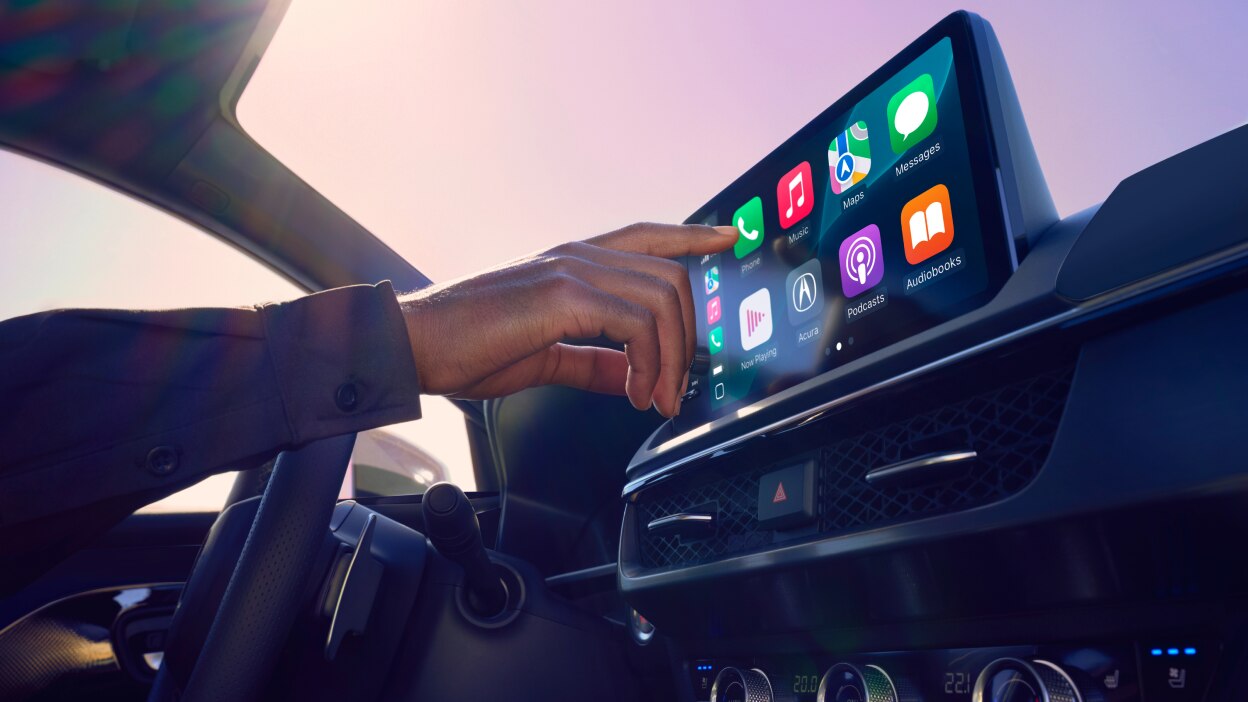 Gros plan de l’habitacle et d’un conducteur manipulant l’écran tactile. 
