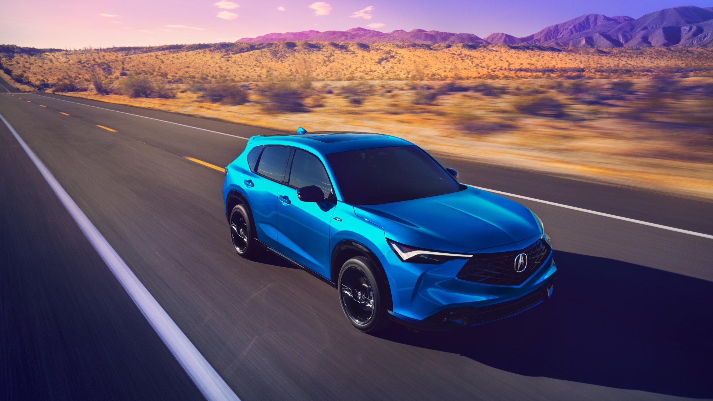 Plan moyen d’un Acura ADX bleu sur une autoroute désertique.