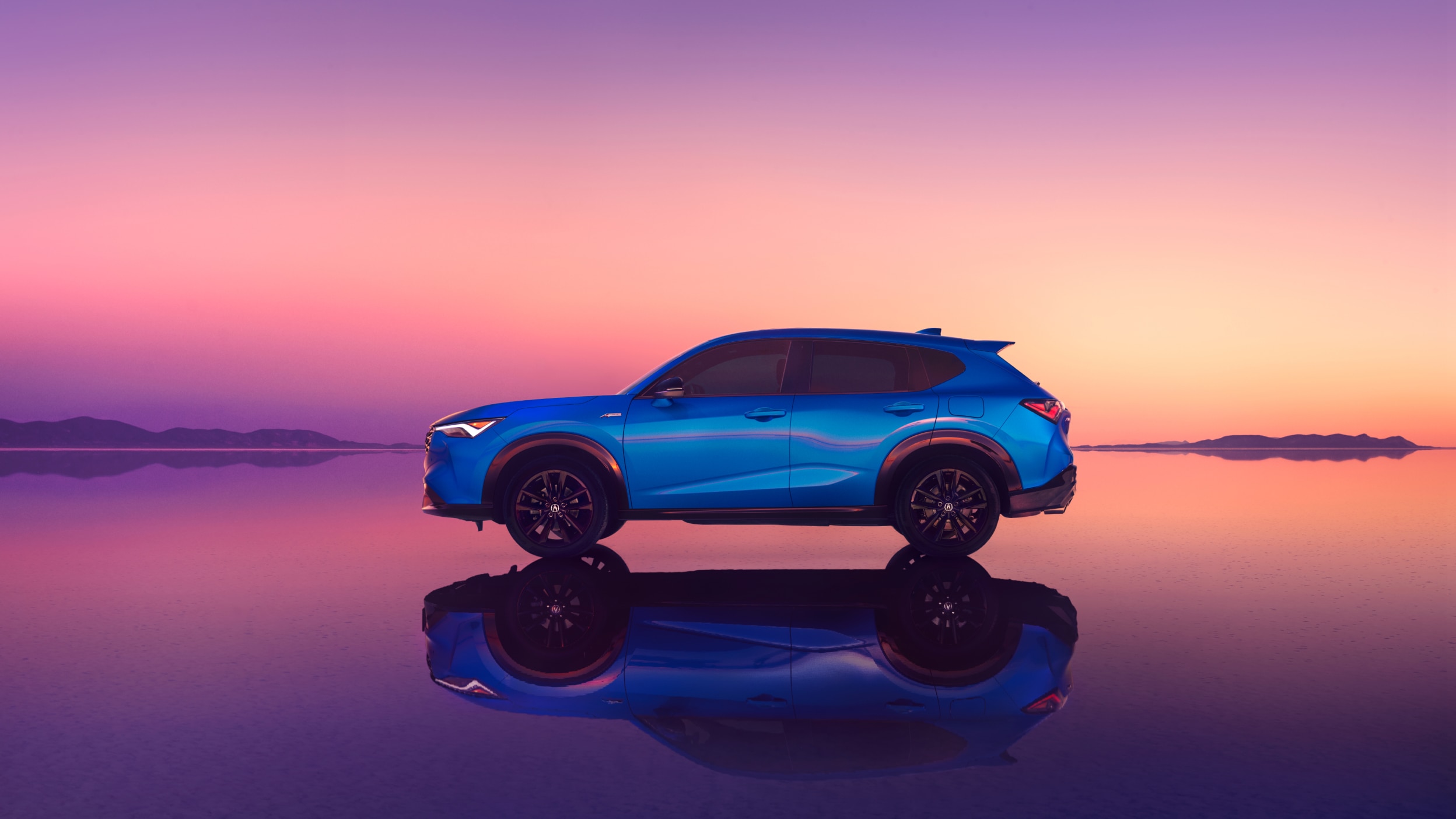 Side-view of an Acura ADX with pink sunset in the background.