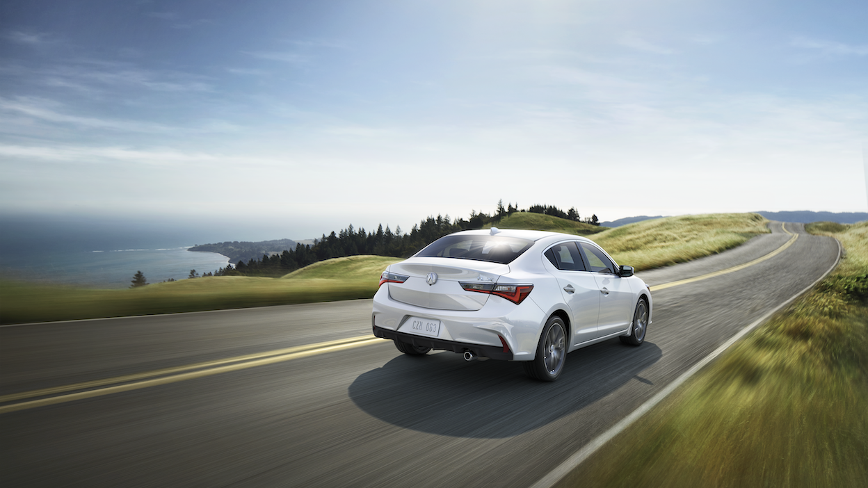 Rear view of 2021 ILX driving along scenic highway.