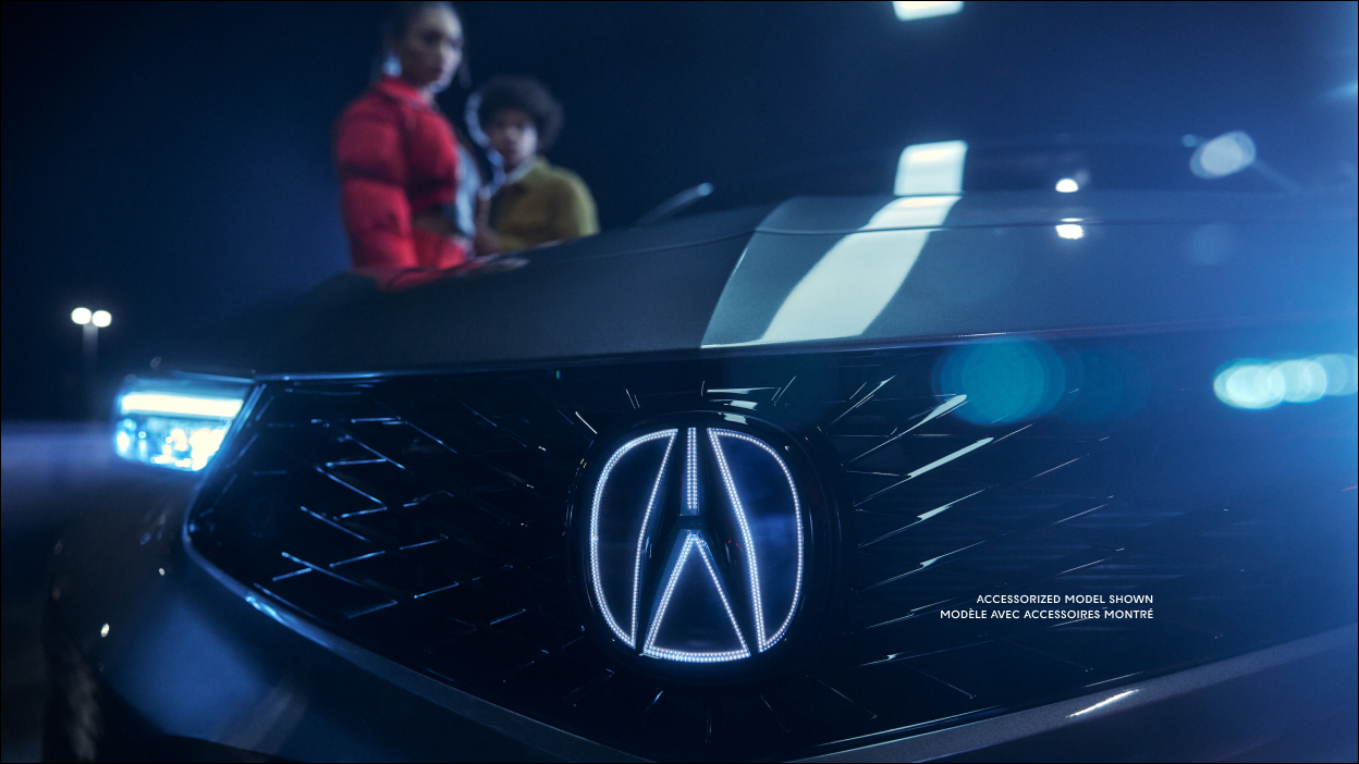 Close-up of 2023 Integra frameless front grill with illuminated Acura badge in dark background