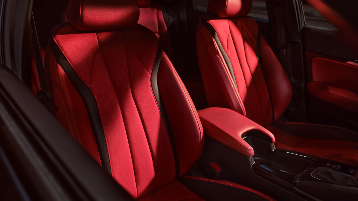 A close-up of 2023 Integra Interior of red Ultrasuede™-trimmed power front seats
