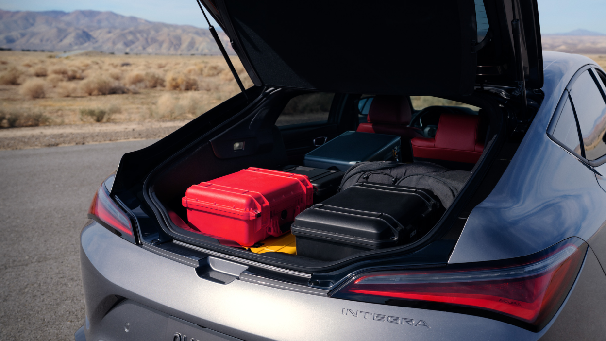 Vue du hayon arrière ouvert de l’Integra 2023 montrant des valises ou des bagages
