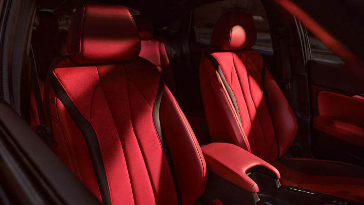 A close-up of 2023 Integra Interior of red Ultrasuede™-trimmed power front seats | Gros plan sur l’habitacle de l’Integra 2023 avec les sièges avant électriques garnis d’Ultrasuede<sup>MC</sup> rouge.