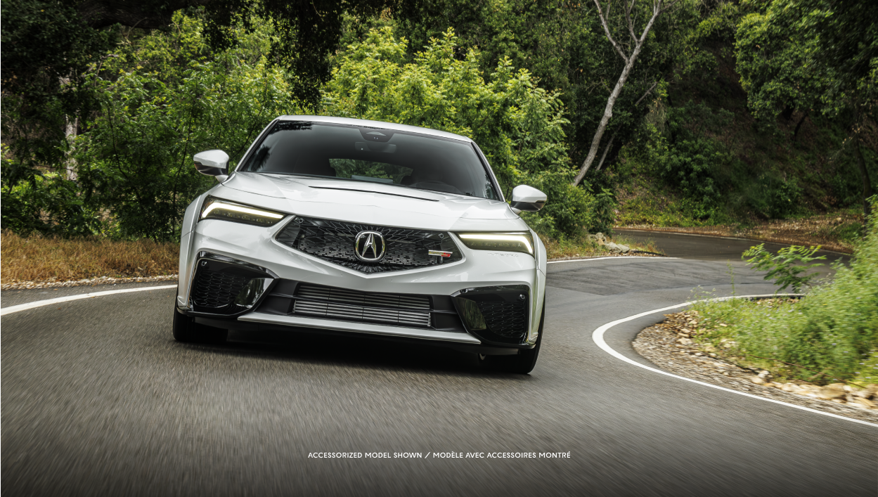Front-view of a white \Integra driving on a forest road. 