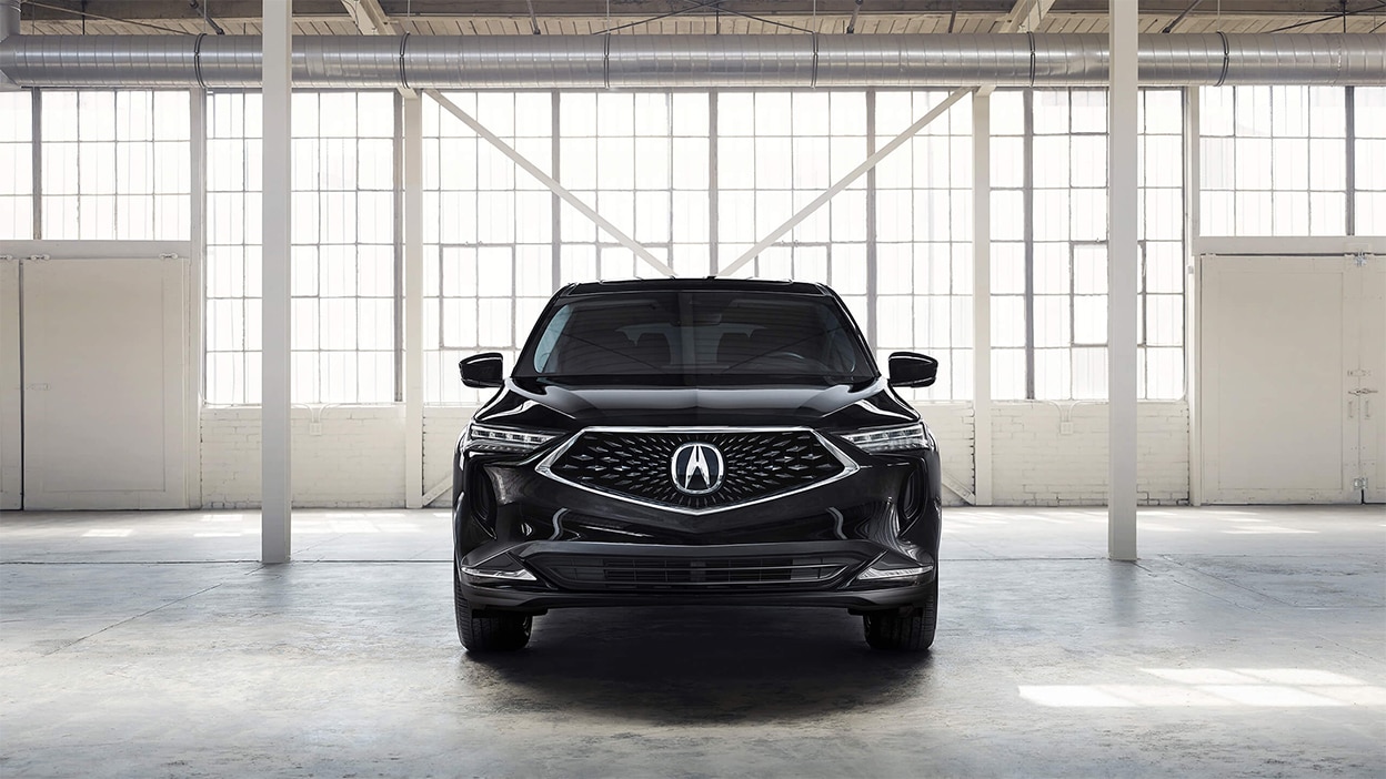 Front view of a black Acura MDX in a bright, spacious warehouse.