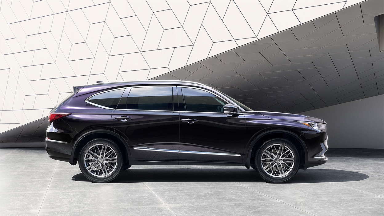 Side view of a purple Acura MDX in a bright, stylish room