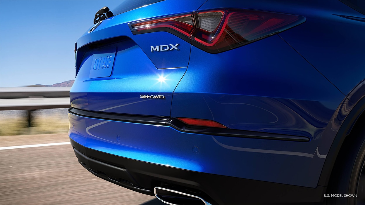 The back of an Acura MDX. We see the trunk and the exhaust pipe.