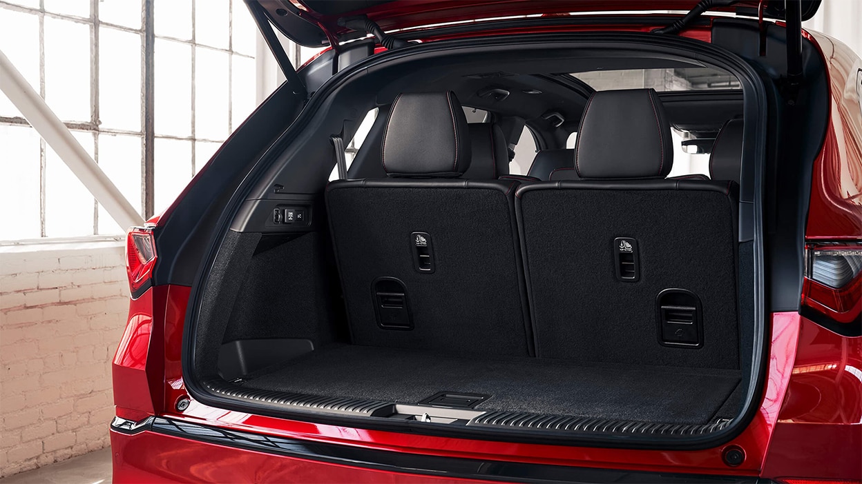 A red MDX with the trunk open, displaying the cargo space.