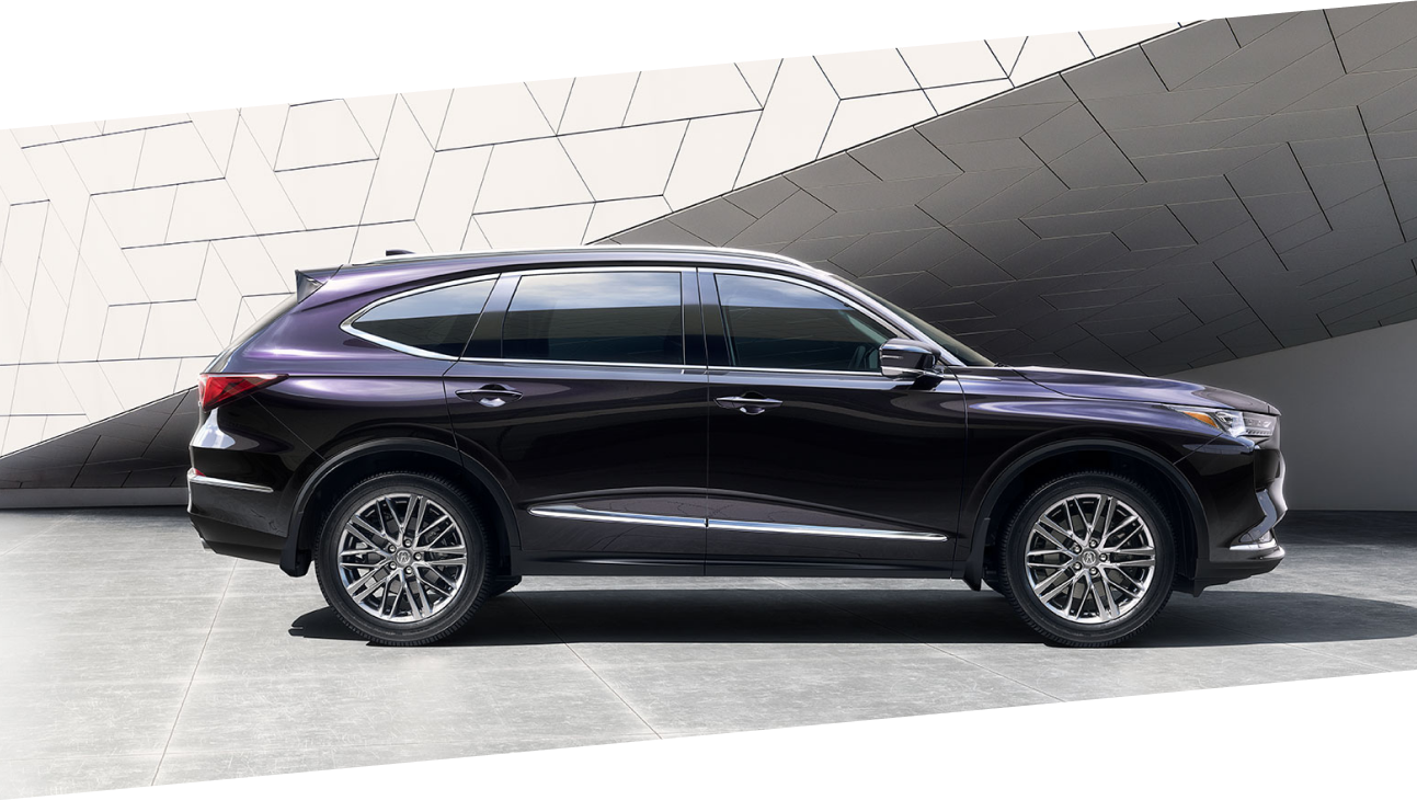 Side view of a purple Acura MDX in a bright, stylish room. / Vue latérale d’un MDX violet dans une pièce élégante et lumineuse.