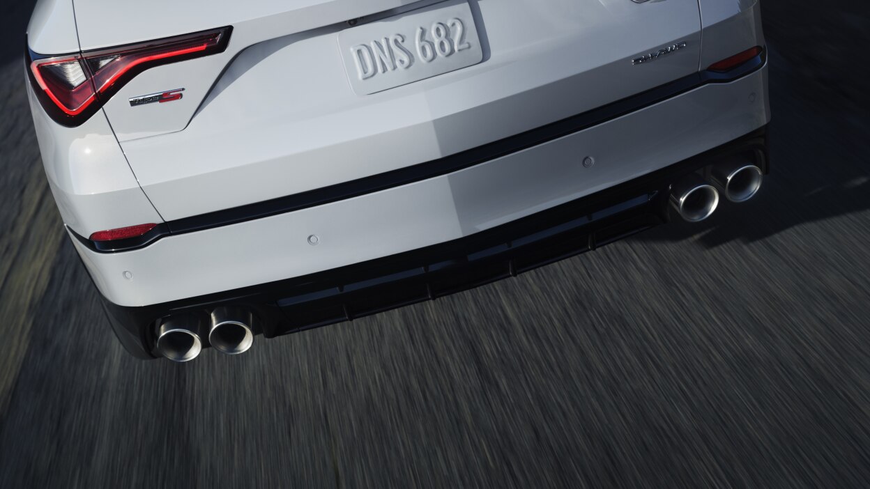 MDX rouge qui prend un virage en pleine nature.