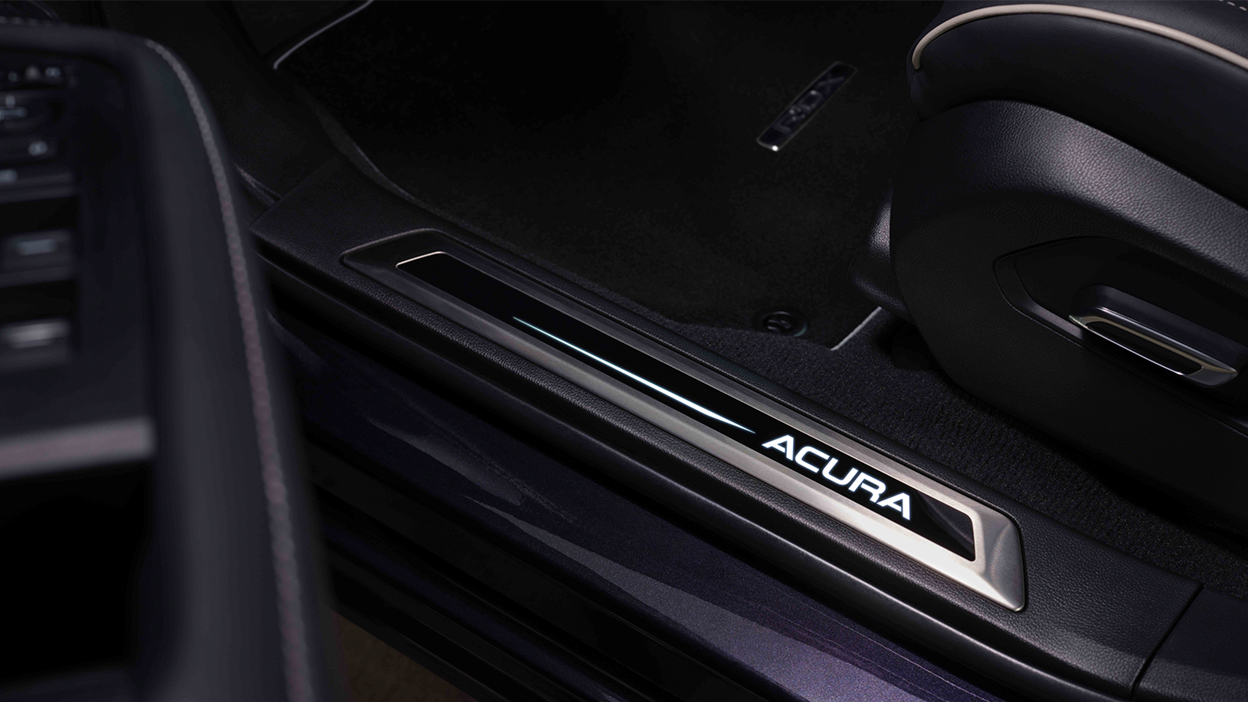 Vue du logo Acura dans le bas de la porte ouverte d’un RDX. 
