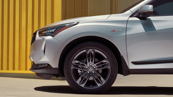 Profile view of front fender of white Acura RDX.