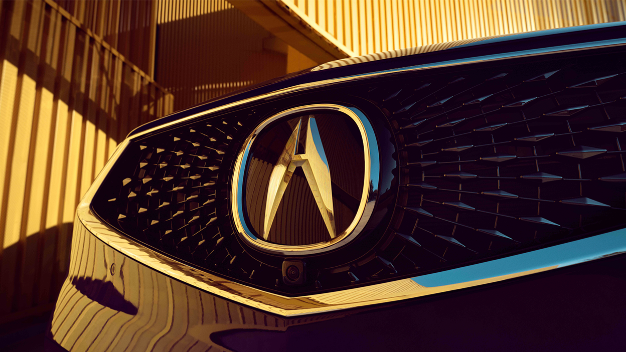 3/4 front view of Acura RDX grille and Acura emblem. 