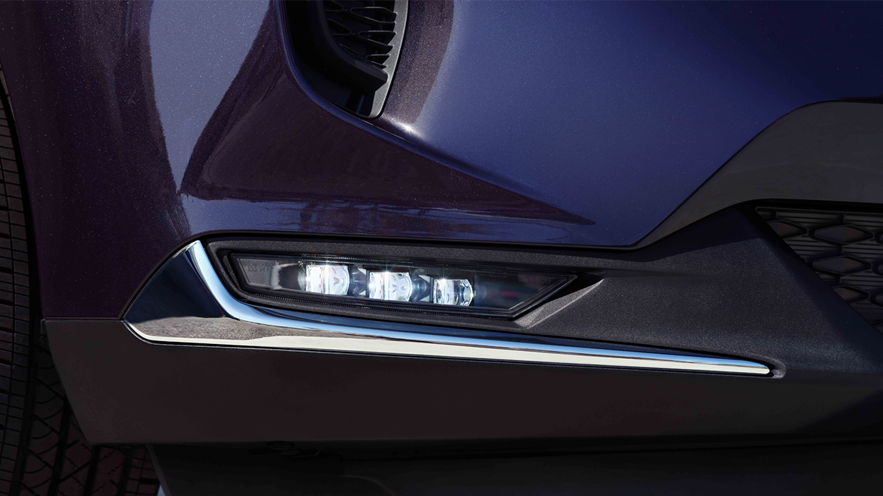 Macro close up of front fog light on blue Acura RDX.
