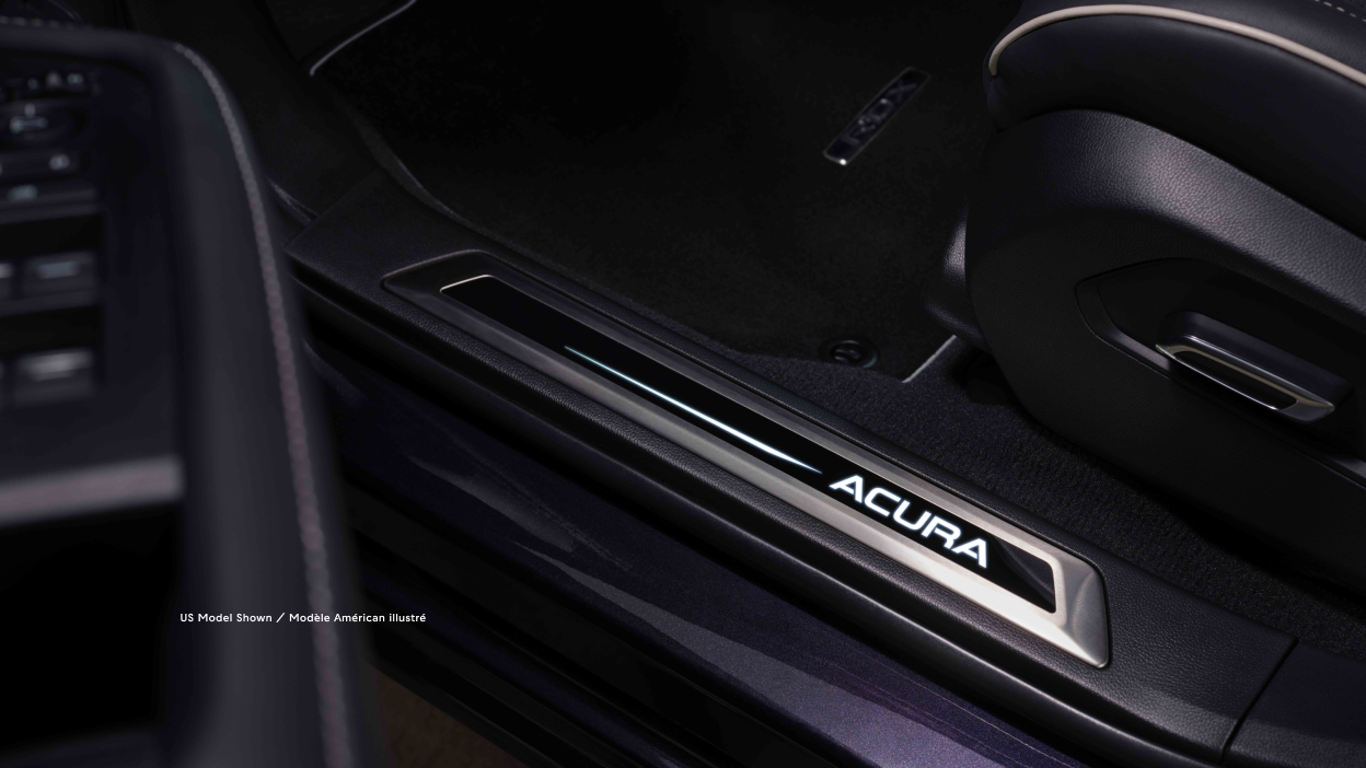 Vue du logo Acura dans le bas de la porte ouverte d’un RDX.