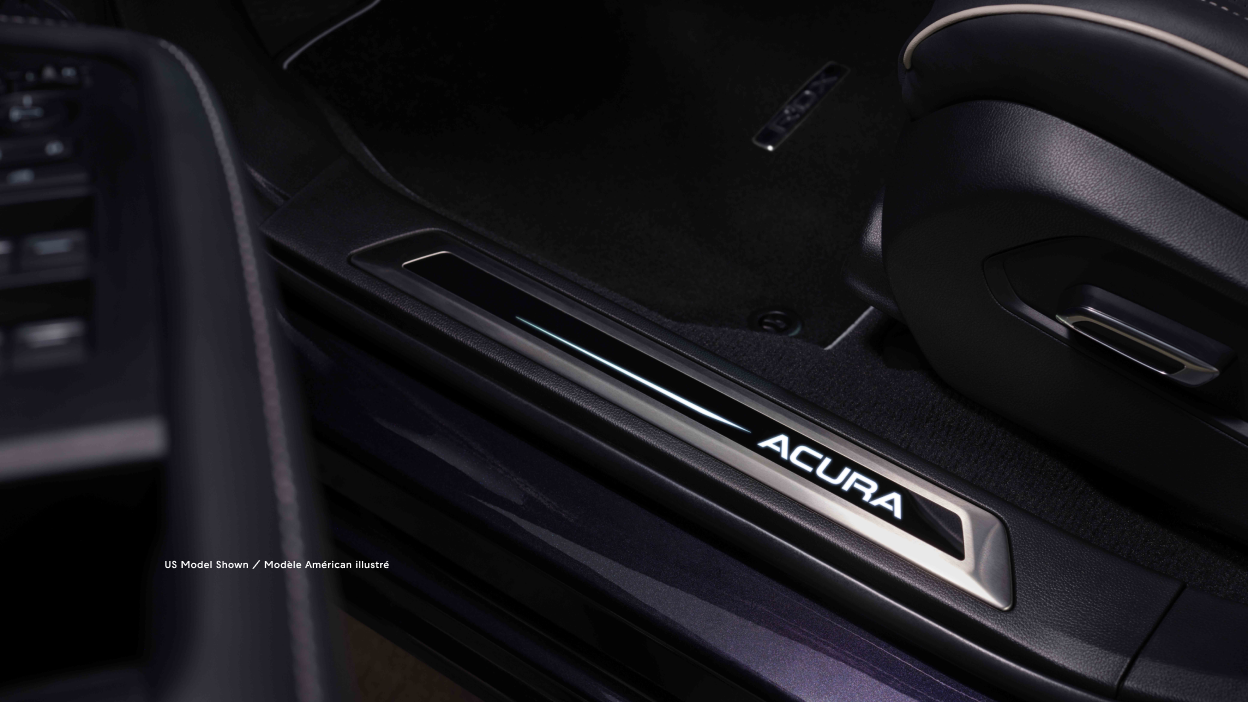 View of Acura logo at the foot of the open RDX door.