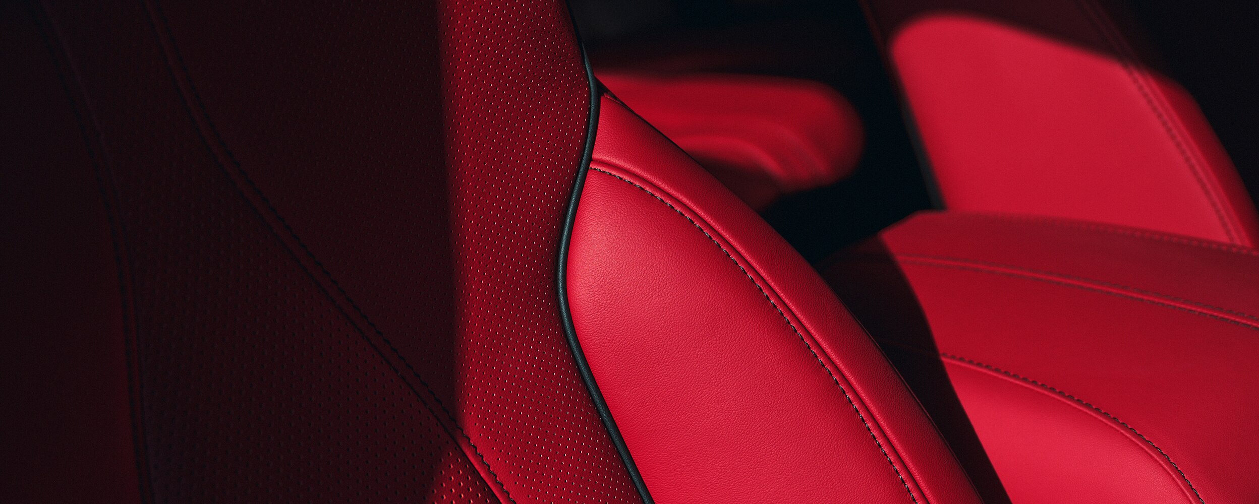 Closeup of red leather seats with Ultrasuede inserts.
