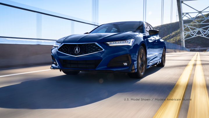 A blue TLX driving over a bridge.