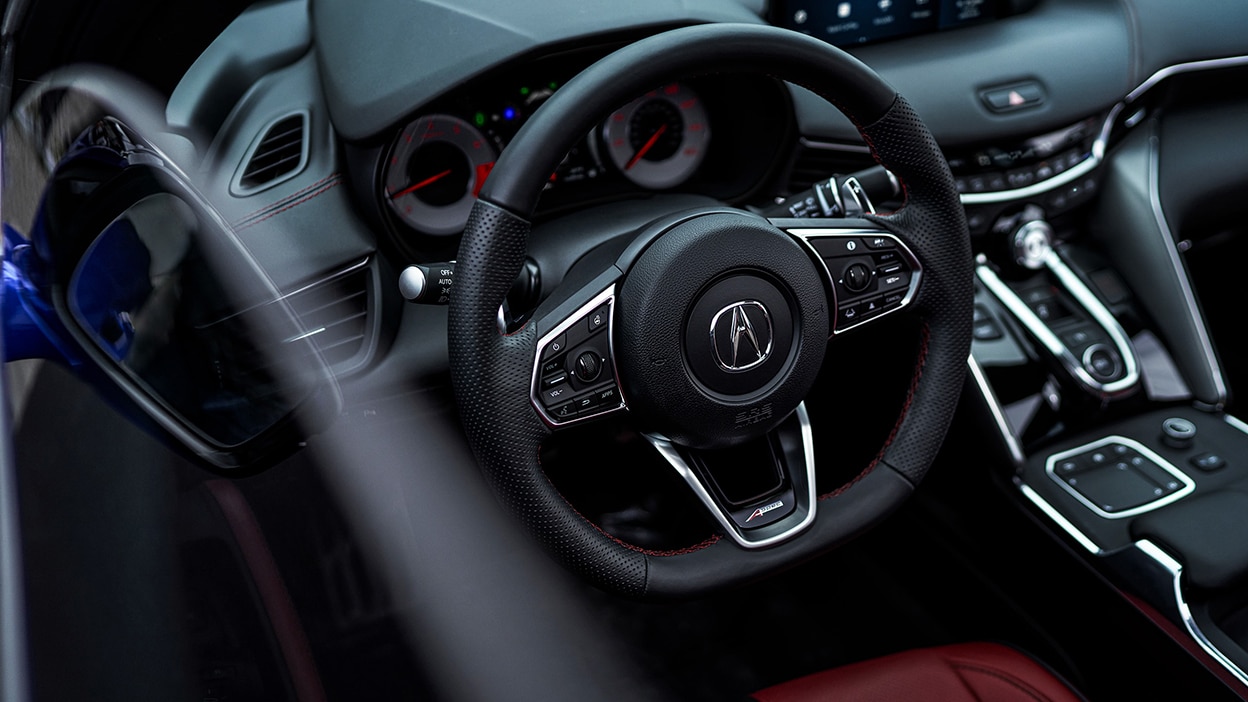 The cockpit of a TLX with Head-Up Display info projected on the windshield.