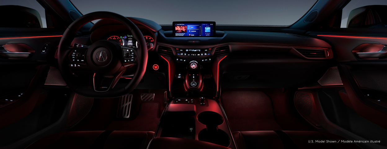 The cockpit of a Acura TLX with red mood lighting. / Habitacle d’une TLX avec éclairage ambiant rouge.