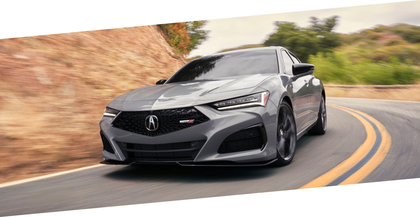 Front closeup of grey TLX Type S taking a turn on highway.