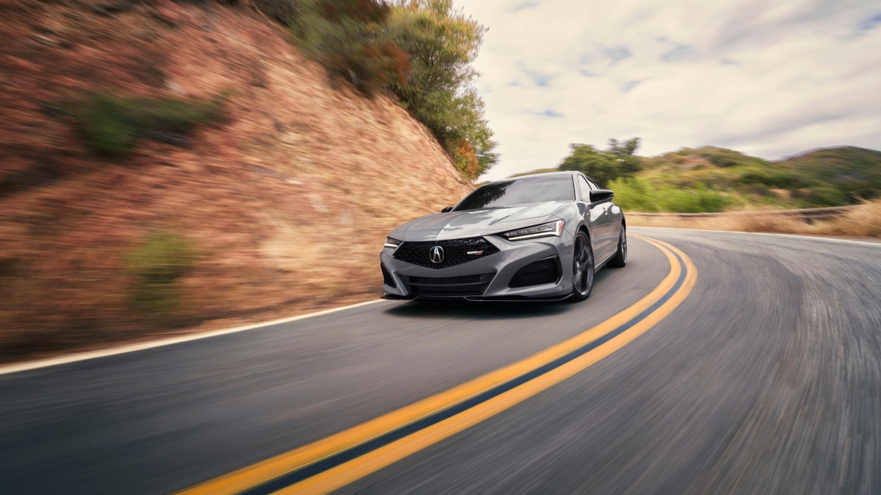 Vue arrière d’une TLX blanche circulant sur un pont.