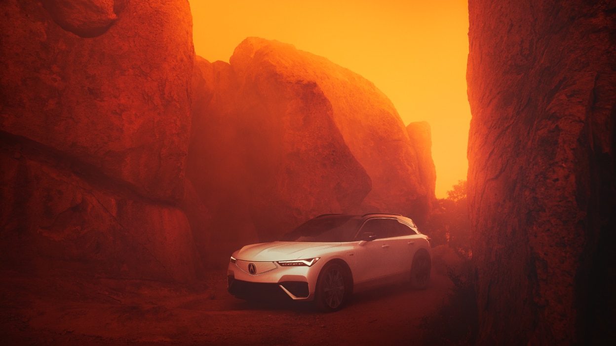 Plan élargi d’un ZDX blanc stationné dans un canyon rocheux au coucher du soleil.