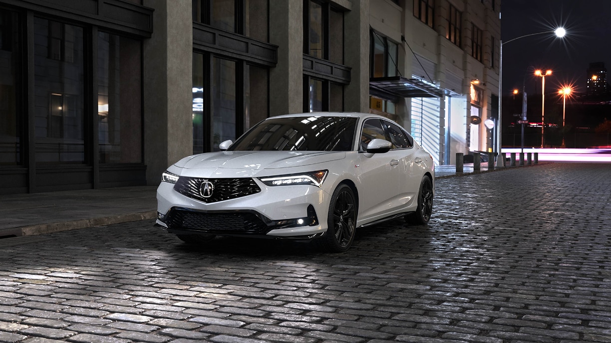 Close-up of a white MDX from the front corner, highlighting the grille and headlight.