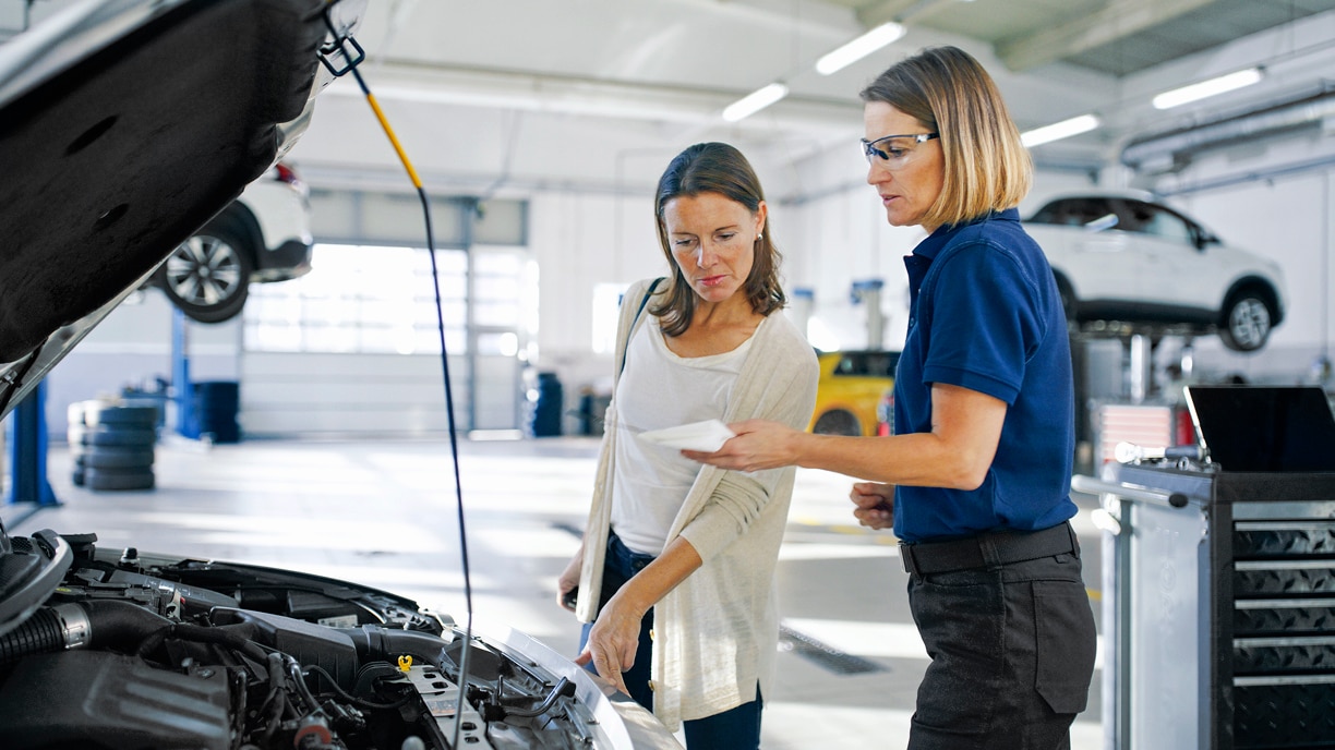 A Acura specialist performs a battery check with a customer.