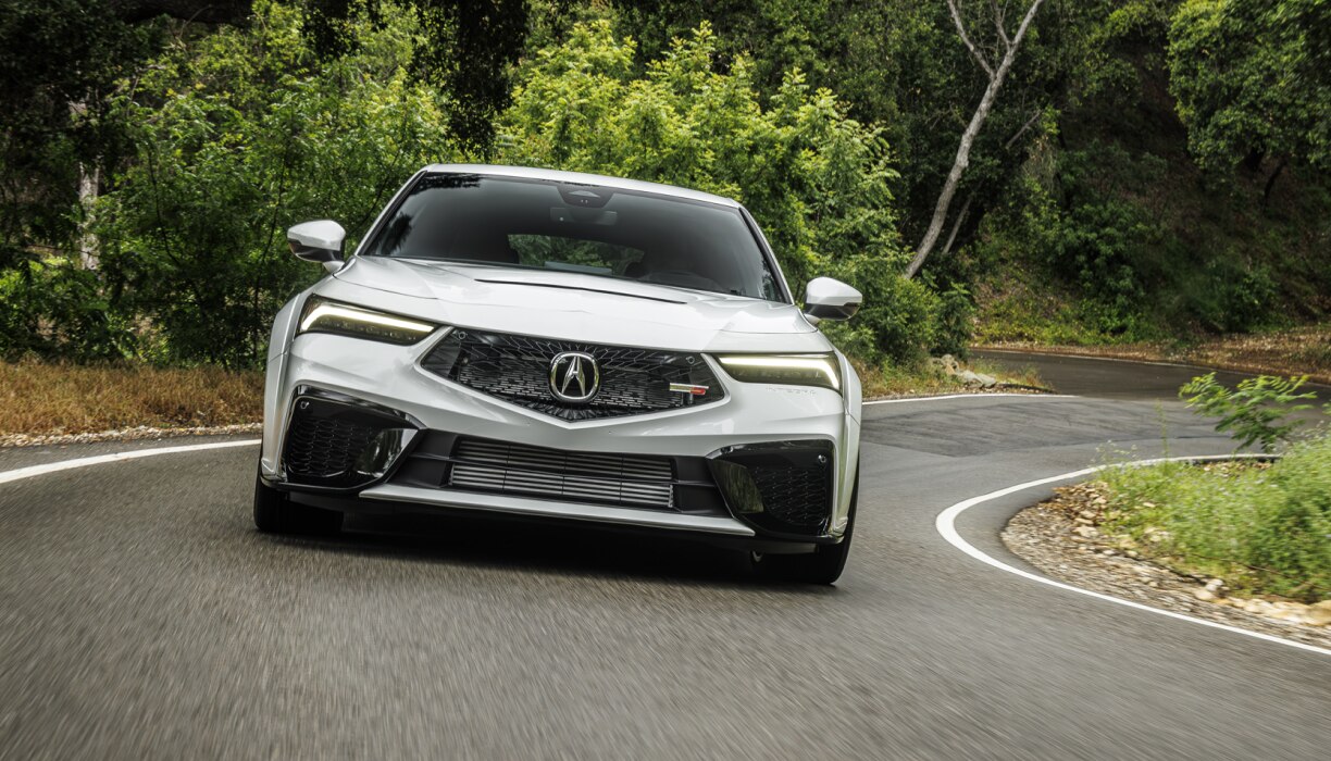 Font view of white acura Integra 2026 driving on a highway