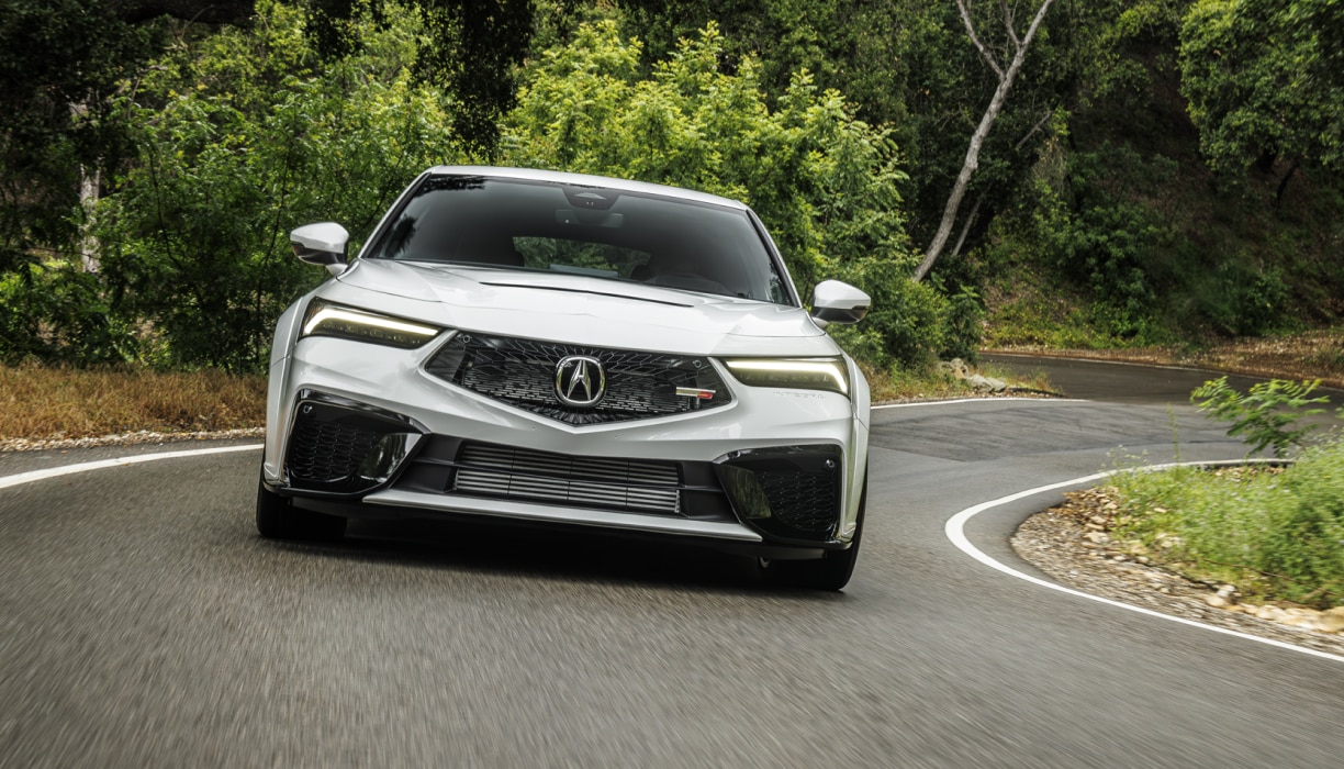 Font view of white acura Integra 2026 driving on a highway