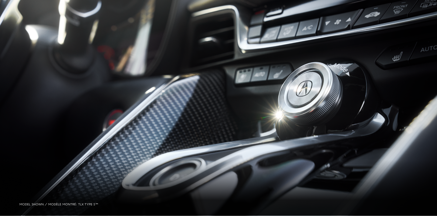 Closeup of dials and buttons on the centre console with carbon fibre accents inside a TLX Type S.
