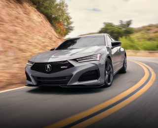 Front view of grey TLX Type S taking a turn on highway.