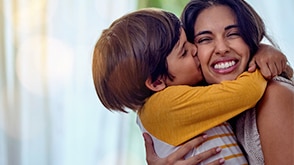 A little boy kisses his mother on the cheek.  / Un petit garçon embrassant sa mère sur la joue.