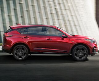 Red Acura RDX A-Spec drives through the city. / Acura RDX A-Spec rouge roulant en ville. 