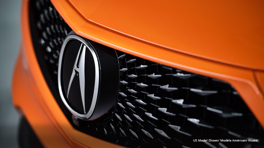 Close-up, angled view of the front grille on an orange Acura MDX.	Gros plan en angle de la calandre d’un Acura MDX orange.
