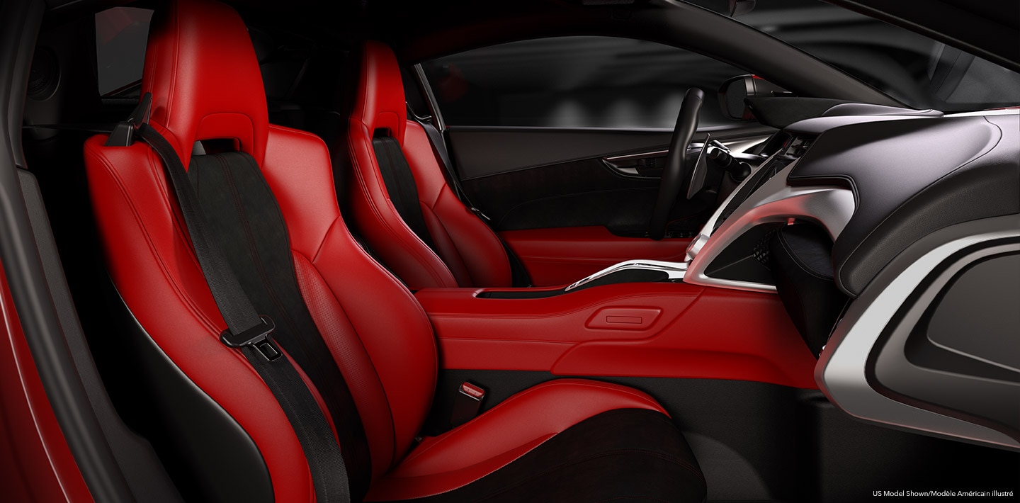 Interior red and black front cabin of an Acura NSX Supercar as seen from the passenger side doorway.	Vue  de l’habitacle avant rouge et noir d’une supervoiture Acura NSX depuis la portière côté passager.