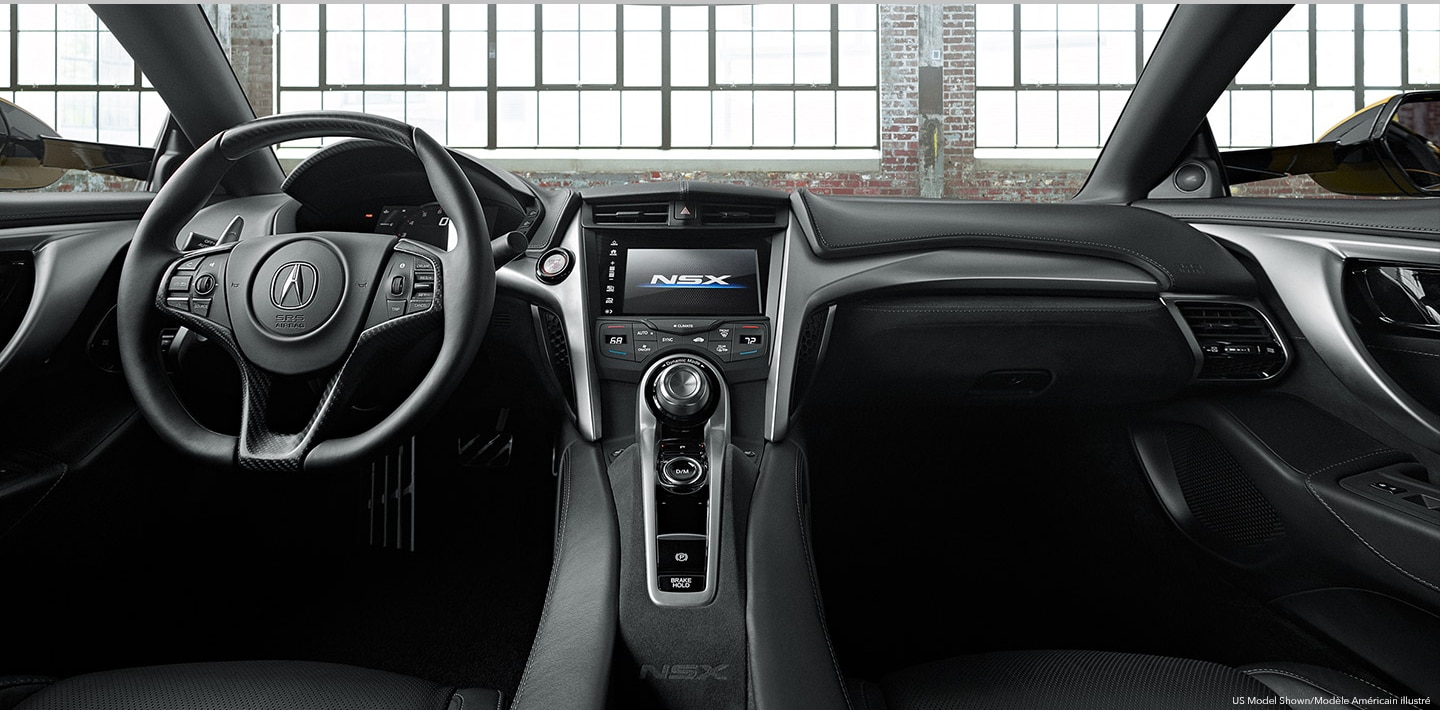 The interior of an Acura's cockpit from the backseat. /  	Vue du cockpit d’une Acura à partir de la banquette arrière.