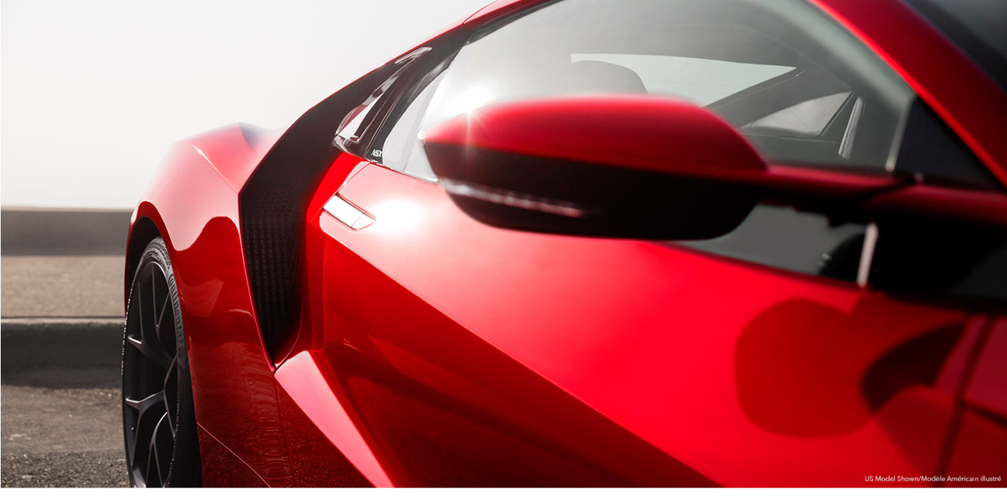 Close-up of the passenger side door and rear fender of a red Acura NSX Supercar.	Gros plan de la porte du côté passager et de l’aile arrière d’une supervoiture Acura NSX rouge.