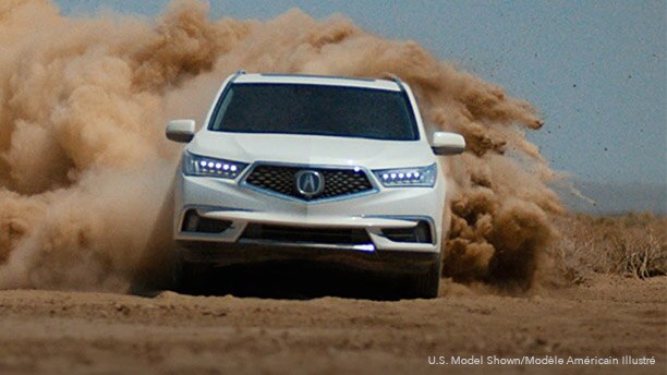 Front view of a white Acura RDX driving through the desert with clouds of sand billowing behind it. // Vue avant d’une Acura RDX blanche roulant dans le désert et créant des nuages de sable sur son passage.