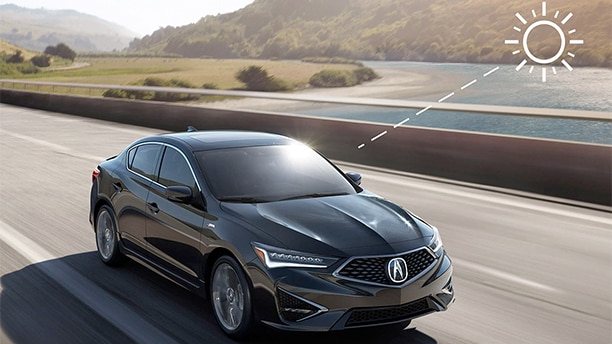 A black Acura TLX drives down the highway. An illustration demonstrates climate control from solar heating. / Une Acura TLX noire roulant sur l’autoroute. L’image montre la régulation de la température à partir du chauffage solaire. 