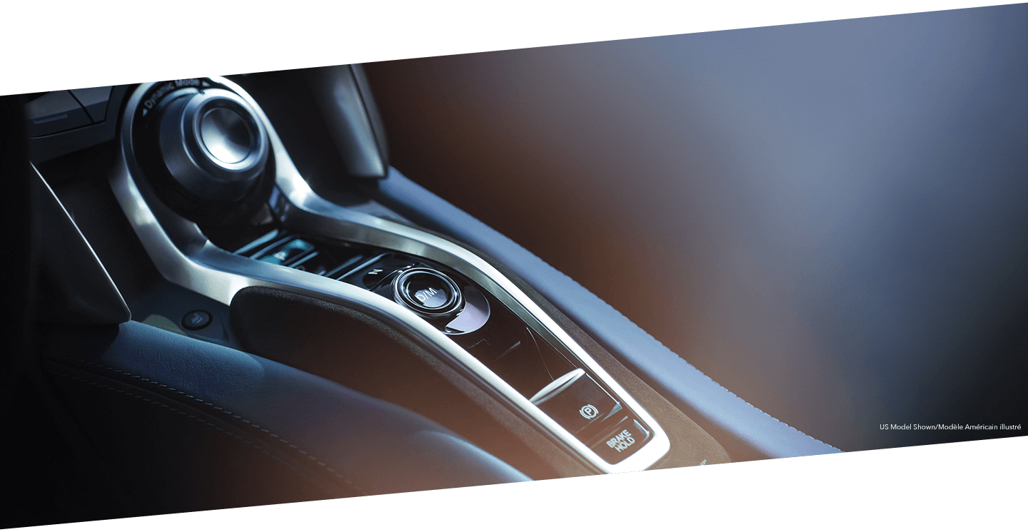 Close-up of the centre console in an Acura NSX showcasing the electric drive mode functionality.	Gros plan de la console centrale d’une Acura NSX qui souligne le mode de conduite électrique.